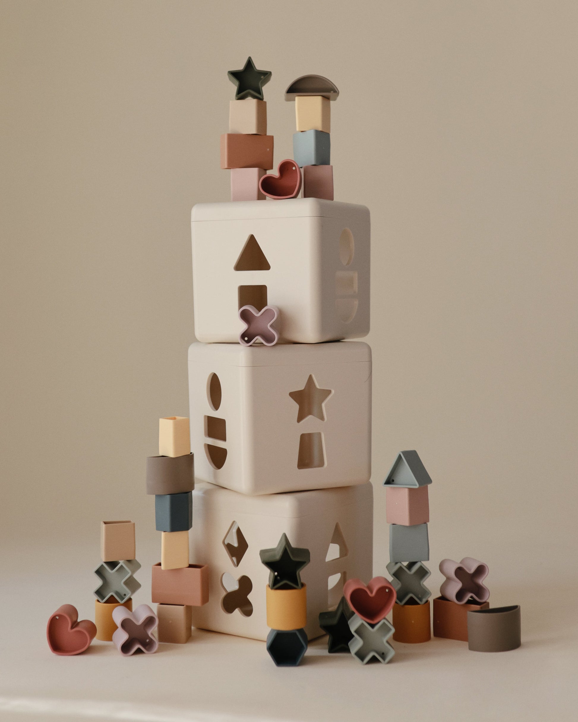 Stack of colorful wooden blocks with various shapes on a neutral background