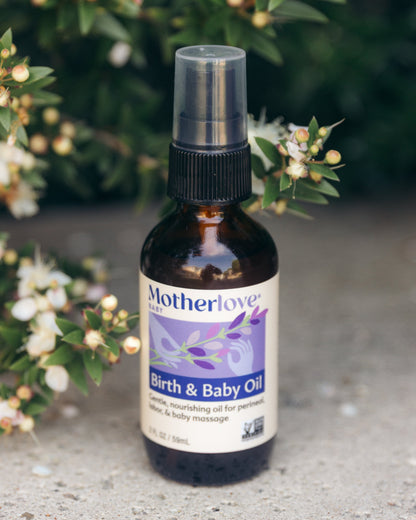 Bottle of Motherlove Birth & Baby Oil with a floral background